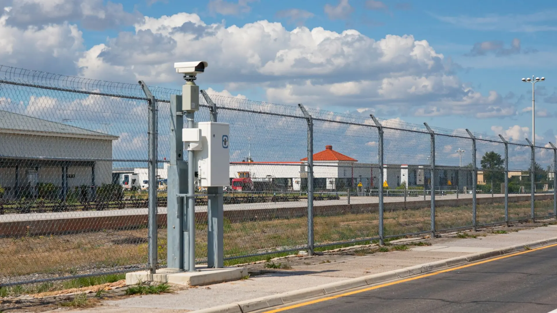 Tall Chainlink Fence with Razor Wire and a Security Camera